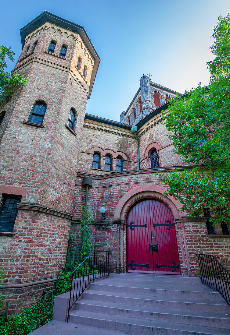 Gebäude mit roter Tür und Backsteinfassade und einem sechseckigen Turm neben dem Eingang eines Gebäudes, Charleston, South Carolina, Vereinigte Staaten von Amerika