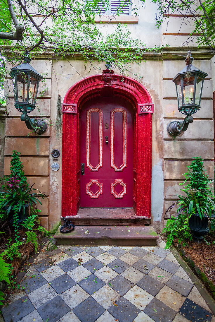 Hauseingang mit roter Tür und zwei großen, beleuchteten Leuchtern, Charleston, South Carolina, Vereinigte Staaten von Amerika