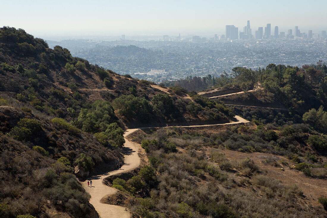 Hikers follow a winding path in the Hollywood Hills. Air pollution hangs over Los Angeles.,Hollywood Hills,Los Angeles,California