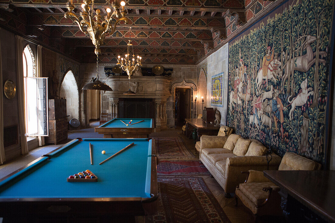 The Hearst Castle billiards room is decorated with furniture,tapestries,artwork and ornate light fixtures.,Hearst Castle,San Simeon,California