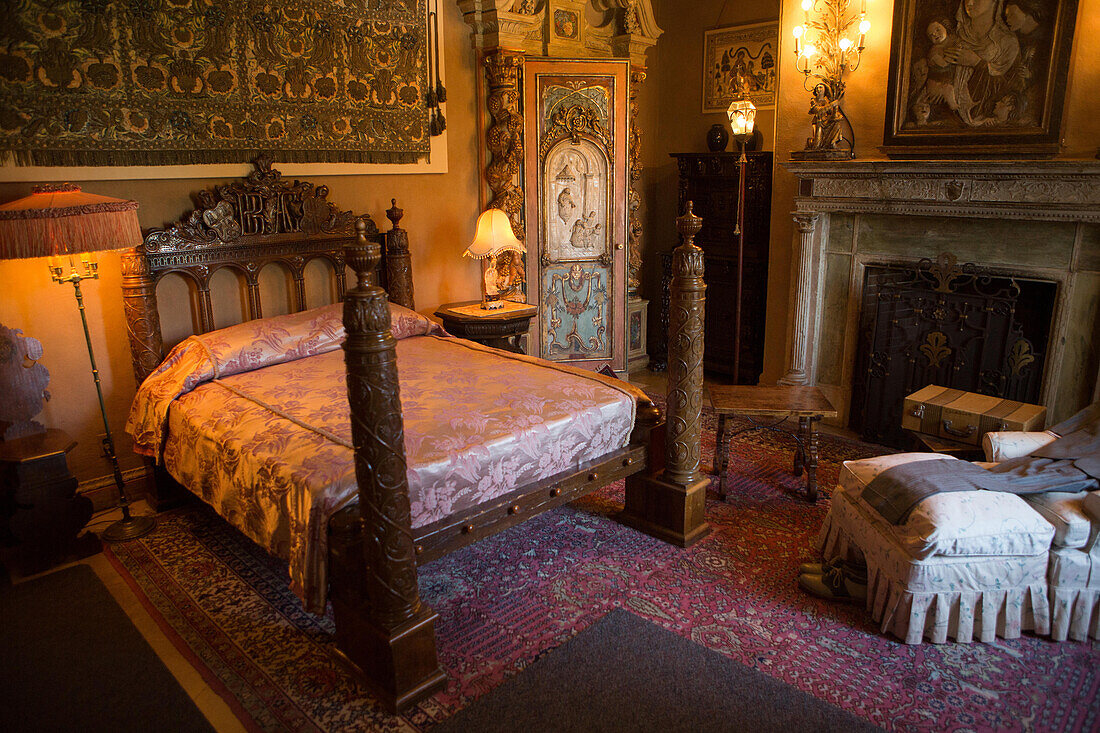 A bedroom decorated with furniture,tapestries,artwork and ornate light fixtures.,Hearst Castle,San Simeon,California