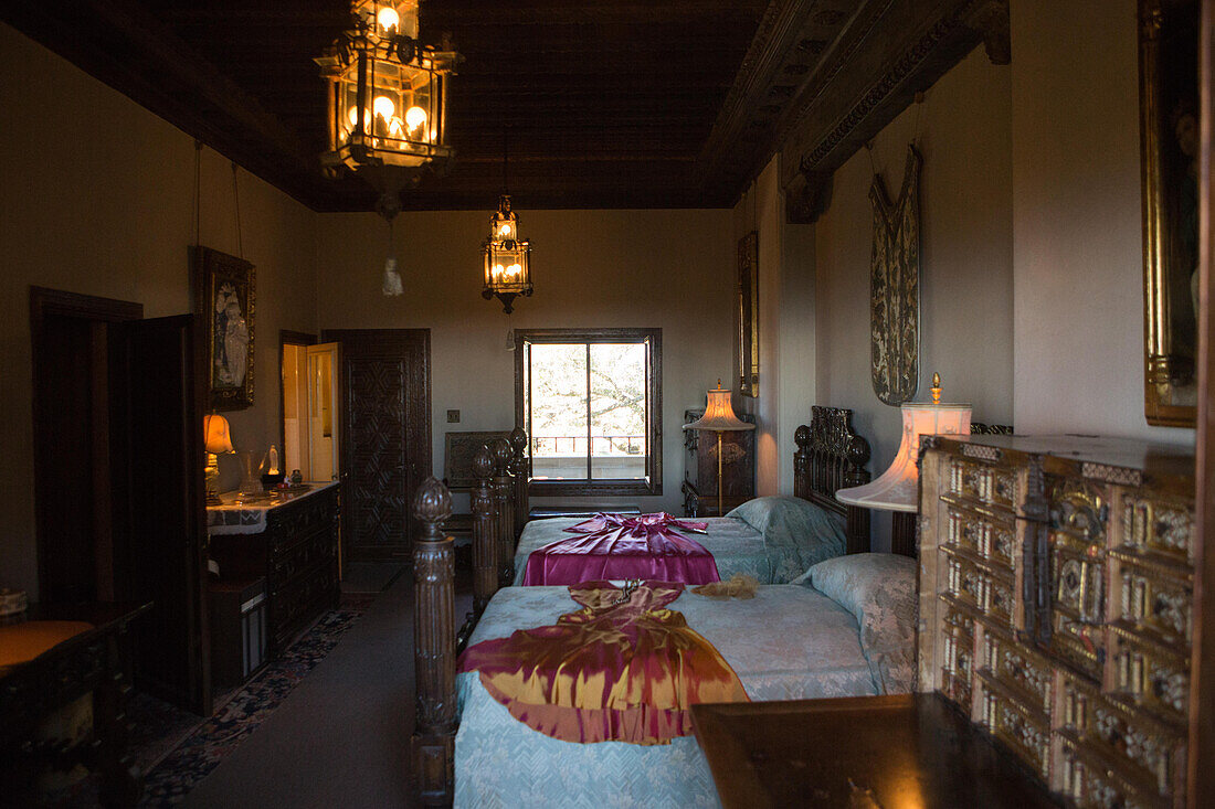 Ein Schlafzimmer mit Möbeln, Kunstwerken und kunstvollen Beleuchtungskörpern, Hearst Castle, San Simeon, Kalifornien