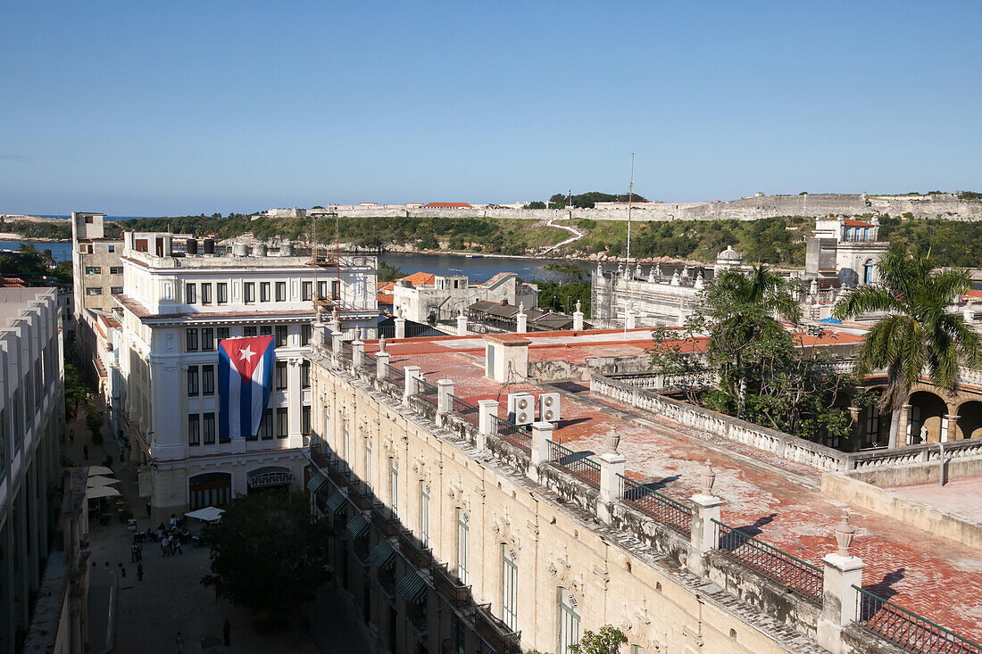 A large Cuban flag hangs on the side of a building in this elevated view to downtown Havana.,Havana,Cuba