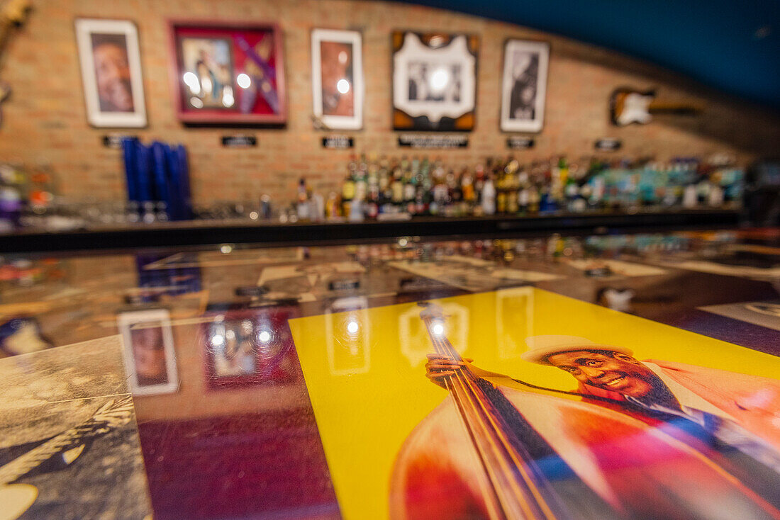 Kunstwerke von Blues-Musikern entlang einer Bar mit Alkoholflaschen in einem Blues-Club, Chicago, Illinois, Vereinigte Staaten von Amerika