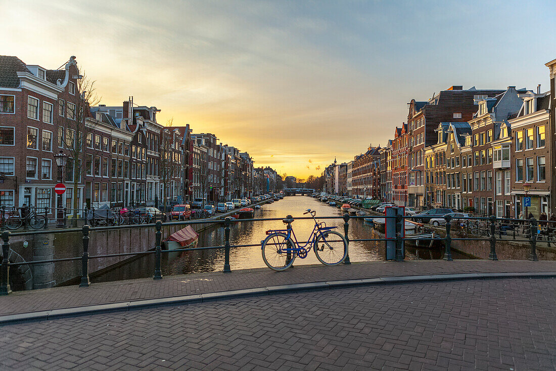 Fahrrad auf einer Grachtenbrücke bei Sonnenuntergang an der Spiegelgracht (Brug 69), Amsterdam, Nordholland, Niederlande