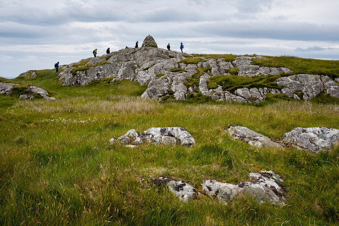 Hikers reach the summit of Dun I,a small hill overlooking the Benedictine Abbey on Iona,Scotland,Iona,Isle of Iona,Scotland