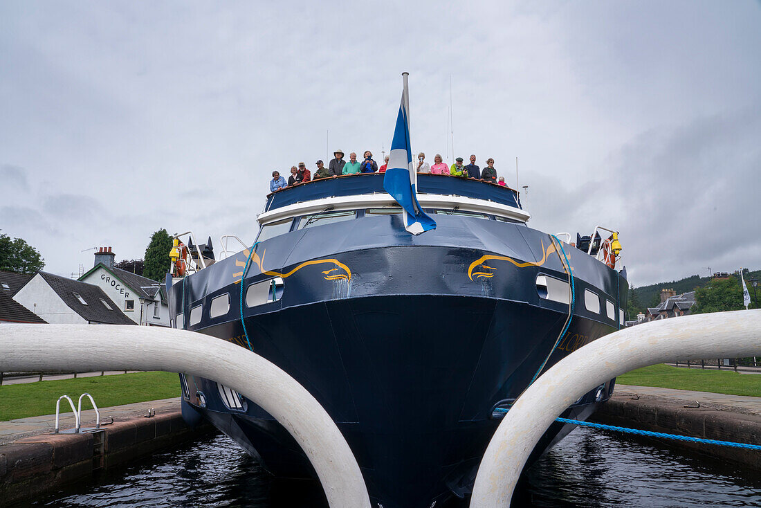 Reisende versammeln sich am Bug eines Ausflugsbootes, um die Einfahrt in eine Schleuse am Caledonian Canal bei Fort Augustus, Schottland, Fort Augustus, Schottland, zu beobachten.