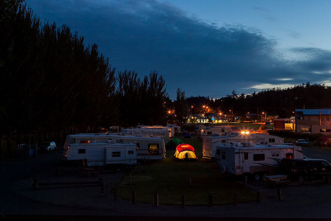 Geparkte und beleuchtete Wohnmobile in der Dämmerung auf einem Campingplatz, Oak Harbor, Washington, Vereinigte Staaten von Amerika