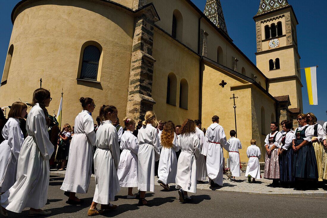 Vor der Pfarrkirche Maria Immaculata im Dorf Weerberg stellen sich Einheimische in traditioneller Kleidung auf, um das Herz-Jesu-Fest mit einer Prozession zu feiern.