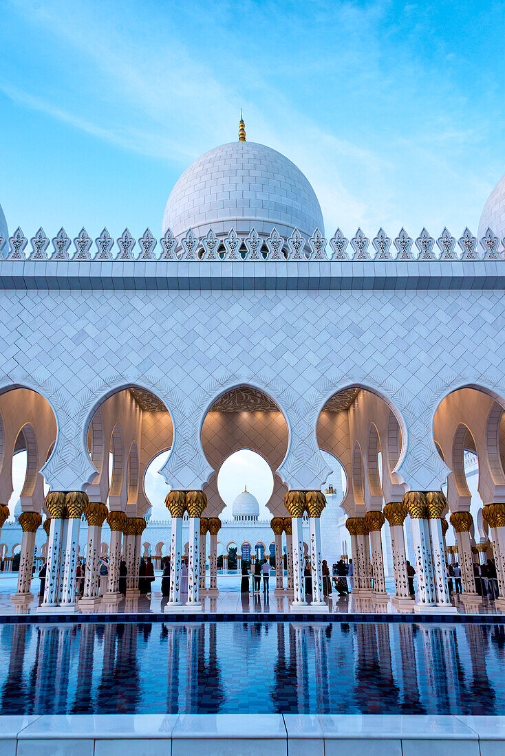 A view looking over one of the reflecting pools into the courtyard at the Grande Mosque in Abu Dhabi,UAE as day fades into night,Abu Dhabi,United Arab Emirates