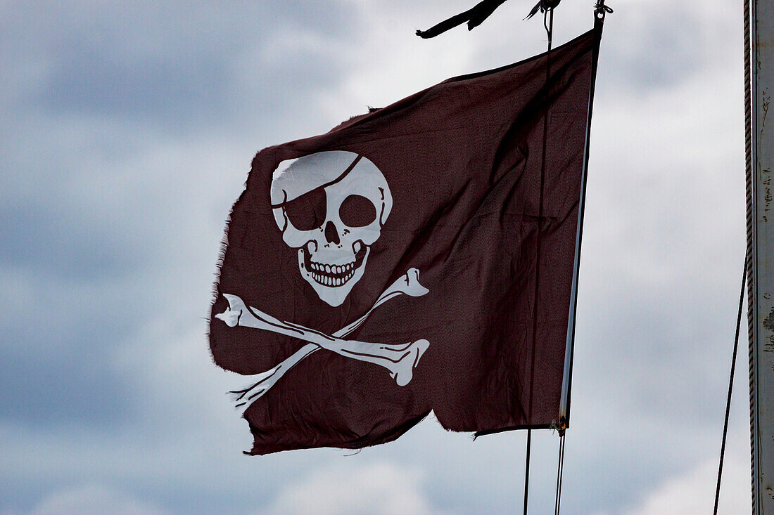 Weathered and worn skull and crossbones pirate flag,England