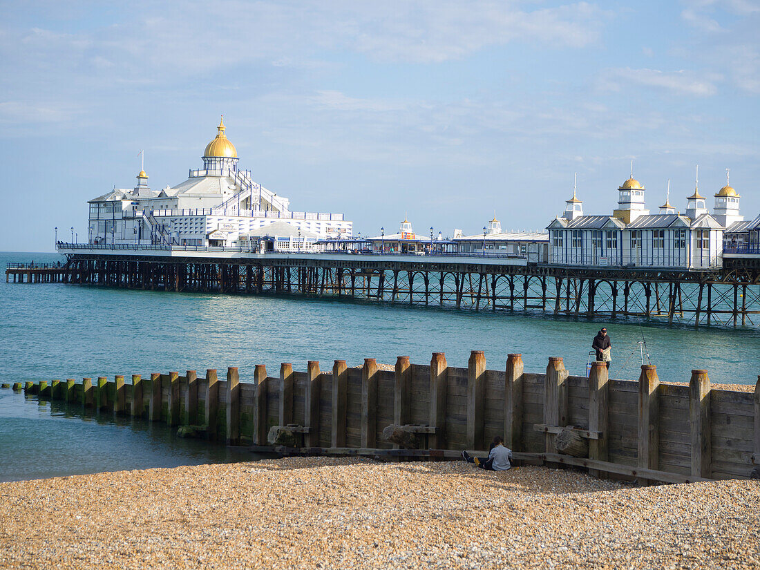 View of the pier with golden dome,calm sea,blue sky and pebble beach,Eastbourne,East Sussex,England