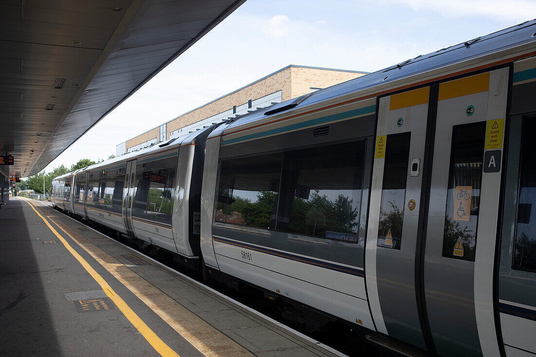 Passenger train on the tracks at a station in the UK,England