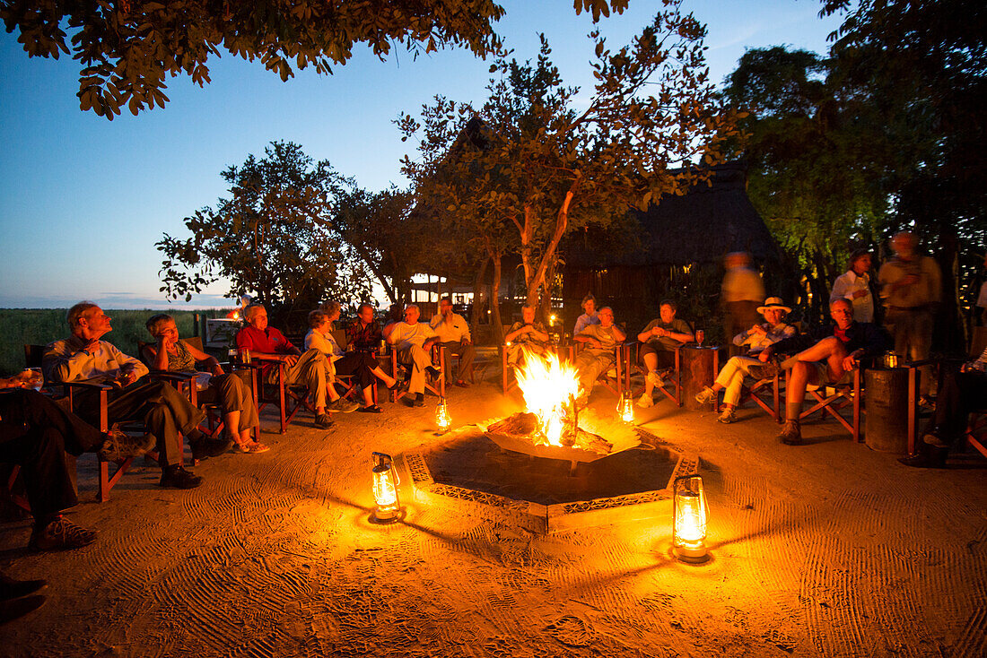 Visitors to the Selinda Reserve enjoy an evening campfire,Selinda Reserve,Botswana