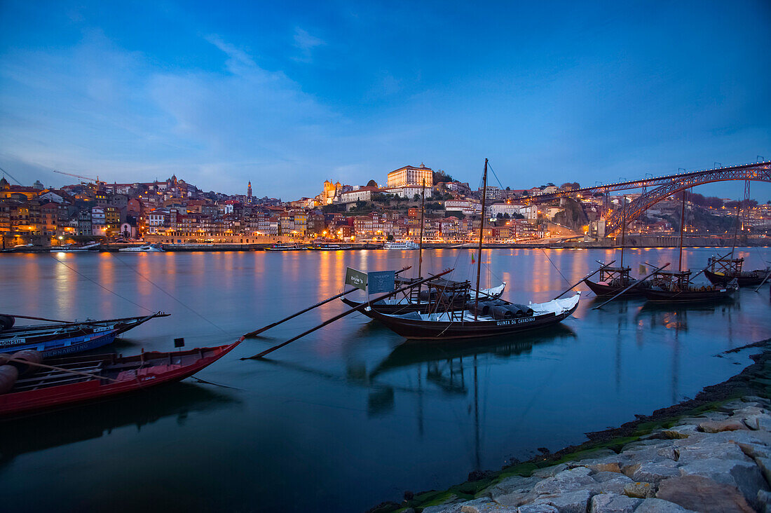 Boats carrying wine barrels in Oporto harbor at dusk,Porto,Portugal
