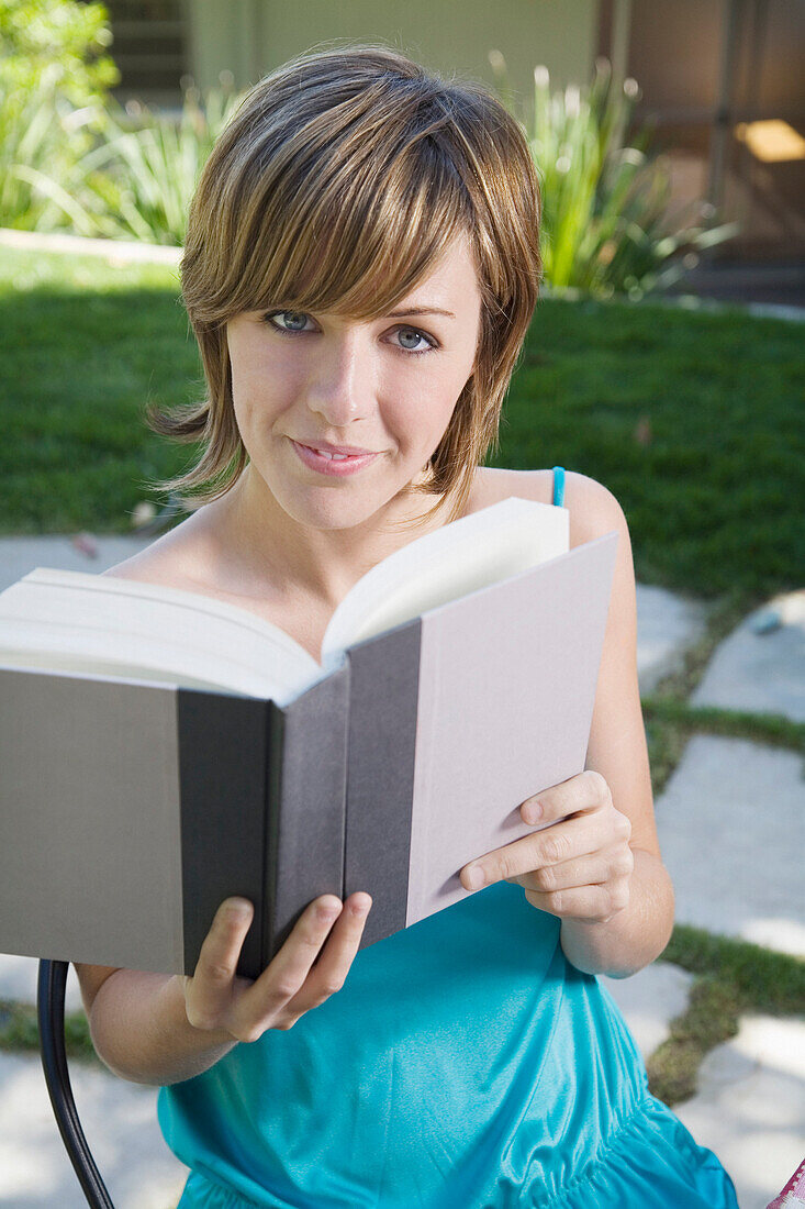 Frau lesend im Hinterhof
