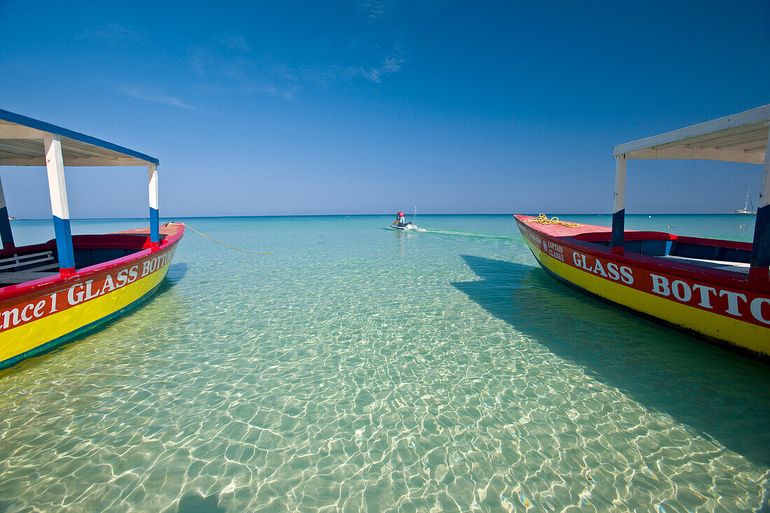 Glass bottomed tourist boats and a motorboat along Negril beach,Negril Beach,Jamaica,West Indies