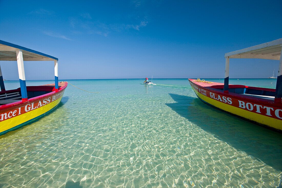 Touristenboote mit Glasboden und ein Motorboot am Strand von Negril, Negril Beach, Jamaika, Westindien