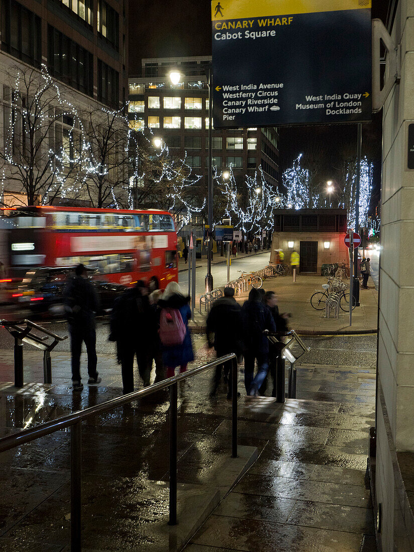 Cabot Square Straßenschild mit Fußgängern, rotem Londoner Bus und schwarzem Taxi bei Nacht, Canary Wharf, London,UK,London,England