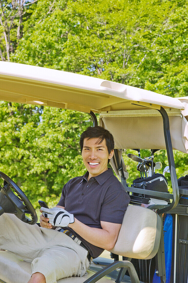 Man in Golf Cart Holding Cell Phone