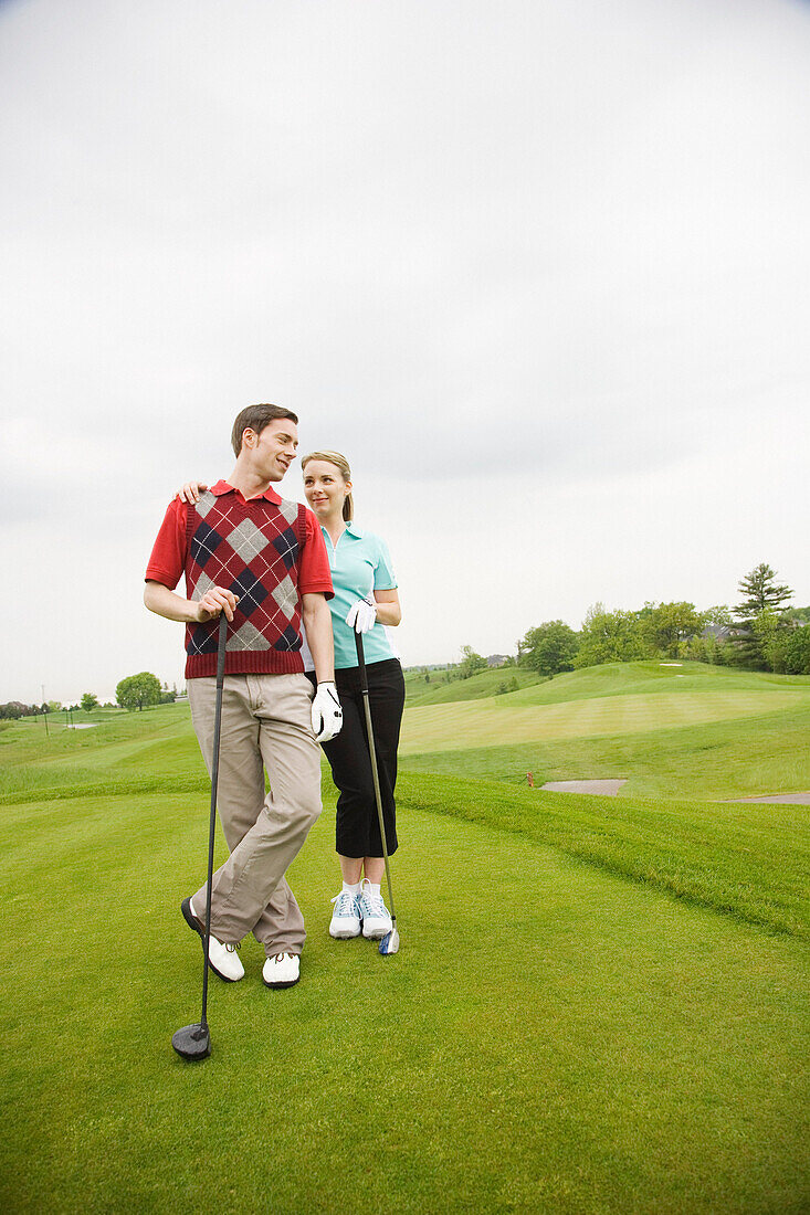 Stehendes Paar auf dem Golfplatz