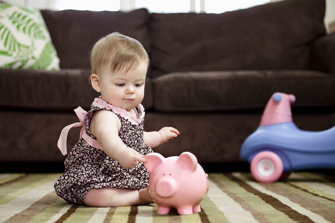 Baby-Mädchen mit Sparschwein