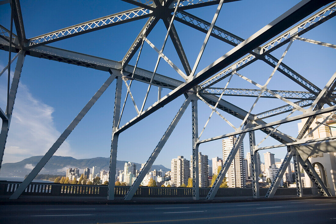 Burrard Street Bridge in the foreground and skyline of residential buildings and the Coast mountains in the background in Vancouver,Canada,Vancouver,British Columbia,Canada