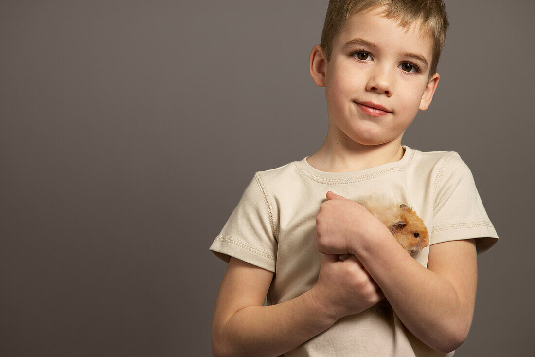 Porträt eines Jungen, der einen Hamster hält