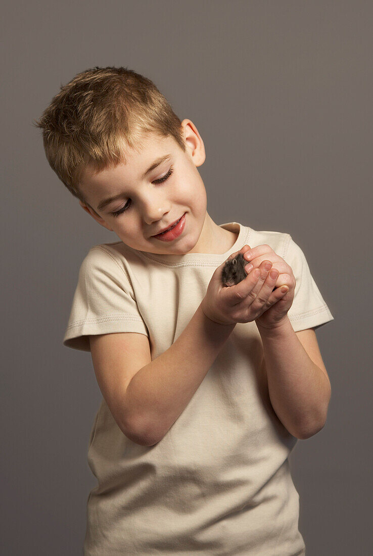 Kleiner Junge hält Hamster