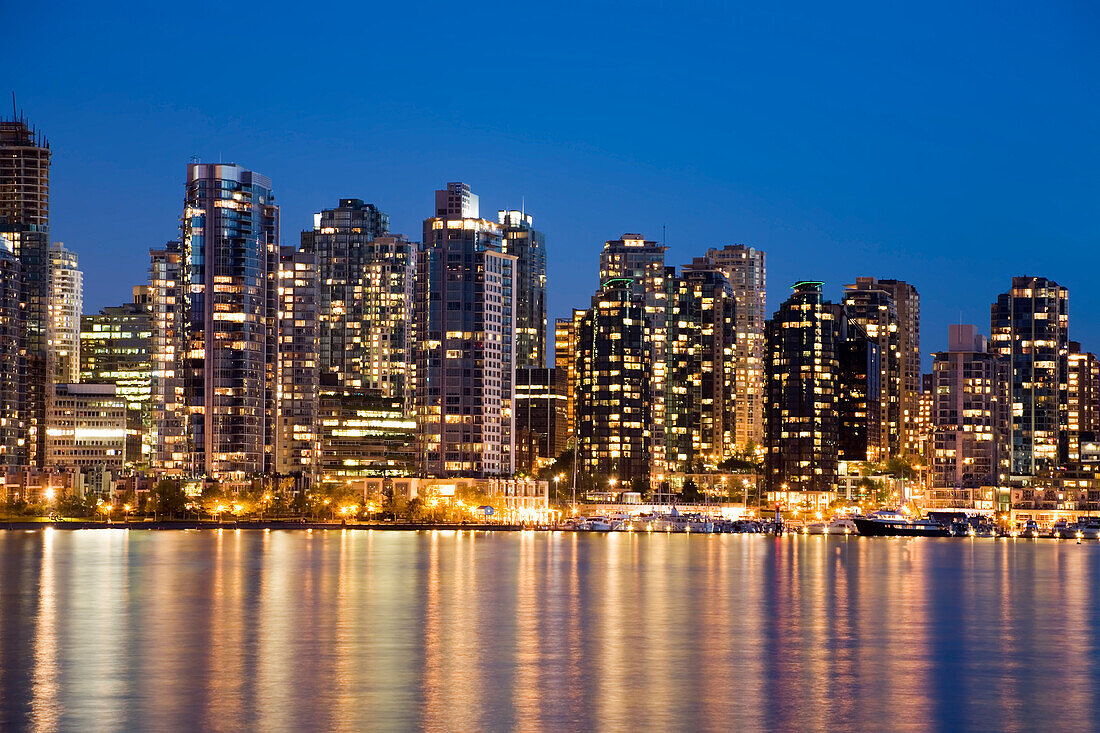 Downtown Vancouver glowing at twilight with illuminated lights across Coal Harbour from Stanley Park,Vancouver,Canada,Vancouver,British Columbia,Canada