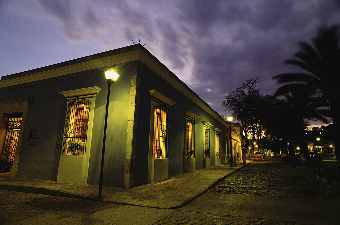 Gebäude und Kopfsteinpflasterstraße in der Abenddämmerung, Oaxaca, Mexiko