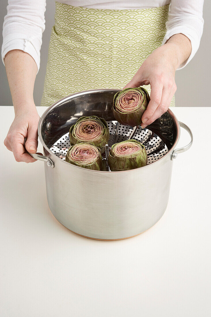 Woman Putting Artichokes in Steamer