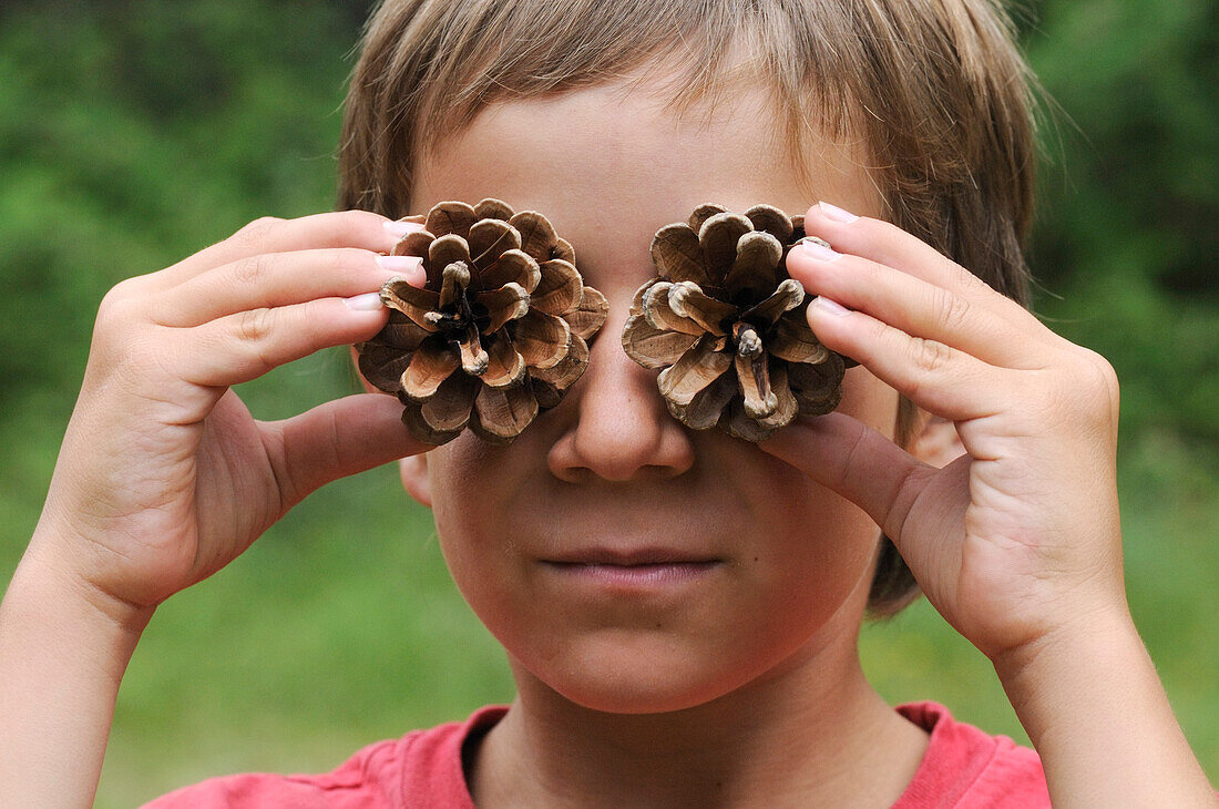 Boy with Pine Cones in Front of Eyes