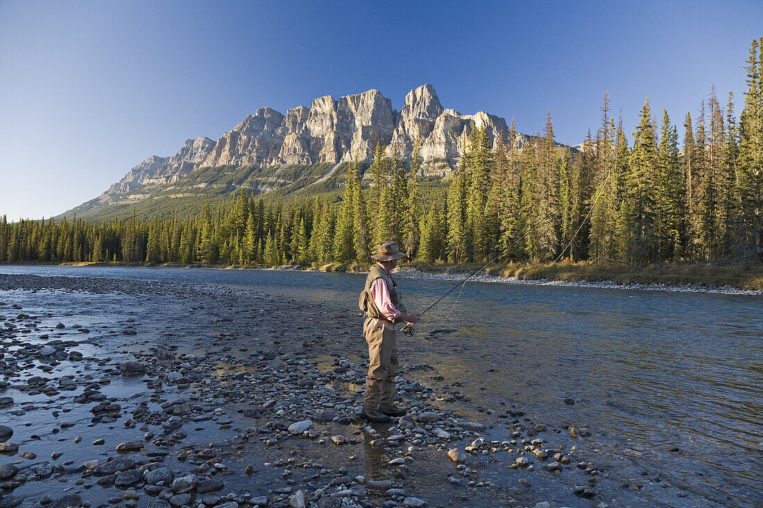 Man Fishing in Mountain River,Banff National Park,Alberta,Canada