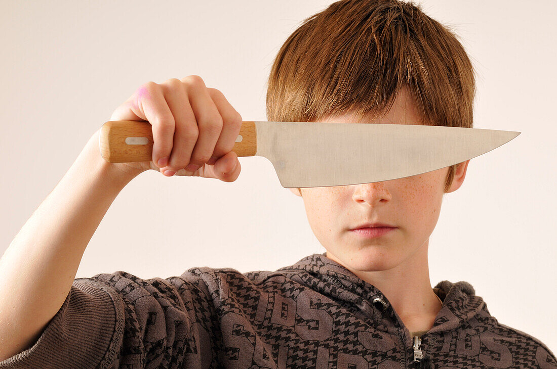 Boy Holding Knife in Front of Eyes