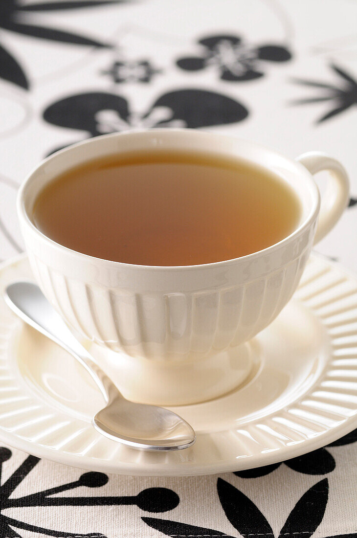 Nahaufnahme einer Teetasse auf Untertasse mit Löffel, Studioaufnahme