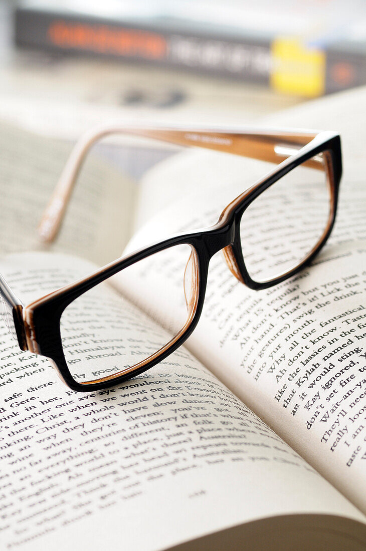 Nahaufnahme einer Brille auf offenem Buch