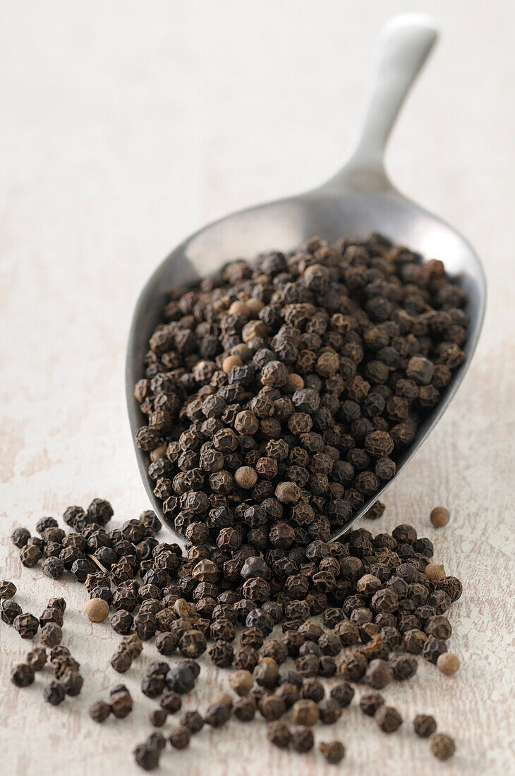 Close-up of Scoop overflowing with Black Peppercorns