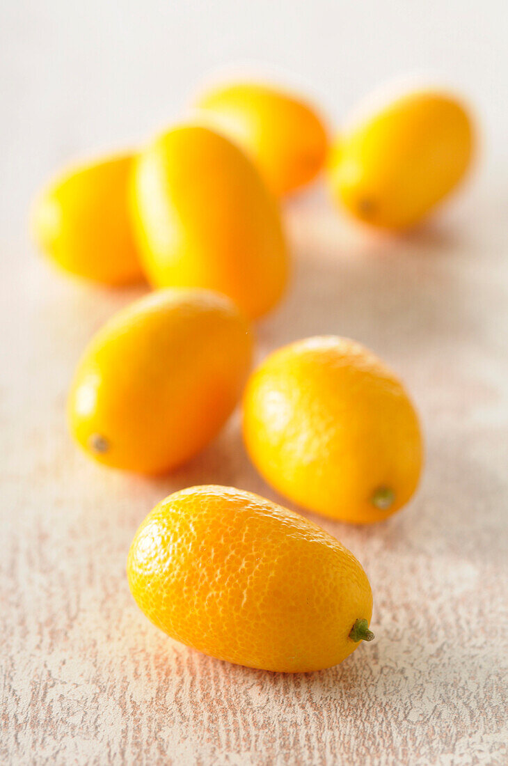 Nahaufnahme von Kumquats auf beigem Hintergrund