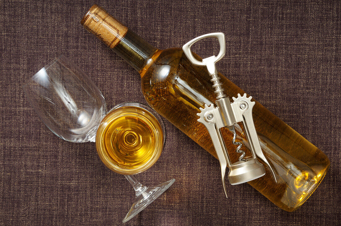Draufsicht auf eine Weißweinflasche, Weingläser und Korkenzieher