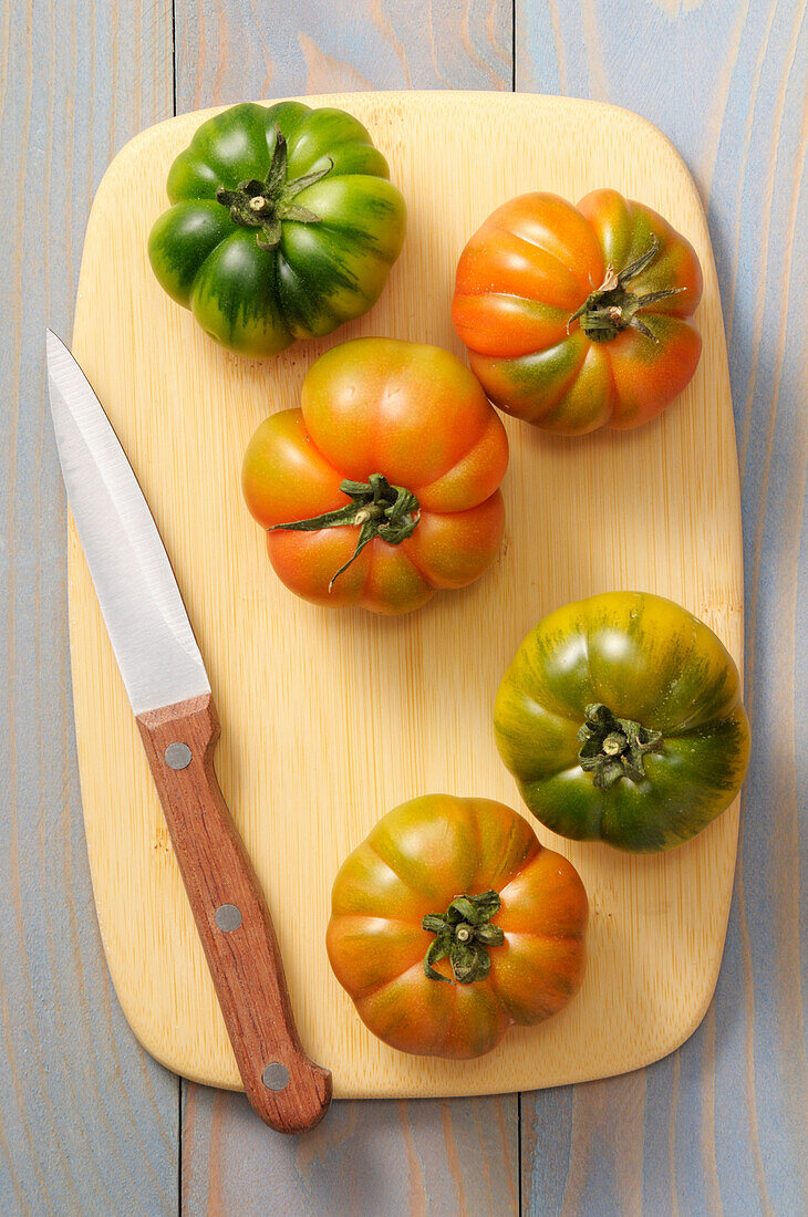 Draufsicht auf Tomaten auf Schneidebrett mit Messer, Studioaufnahme