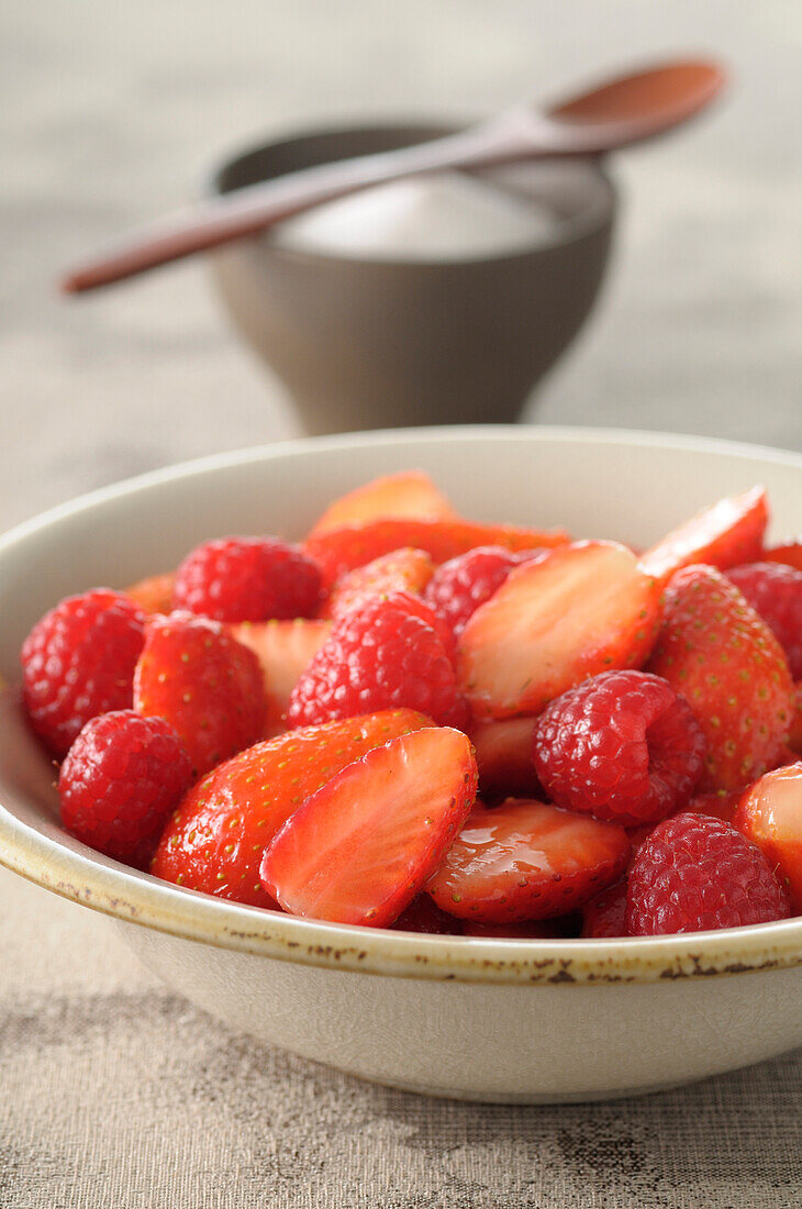 Close-up of Bowl of Strawberries and Raspberries with Bowl of Sugar in Background,Studio Shot