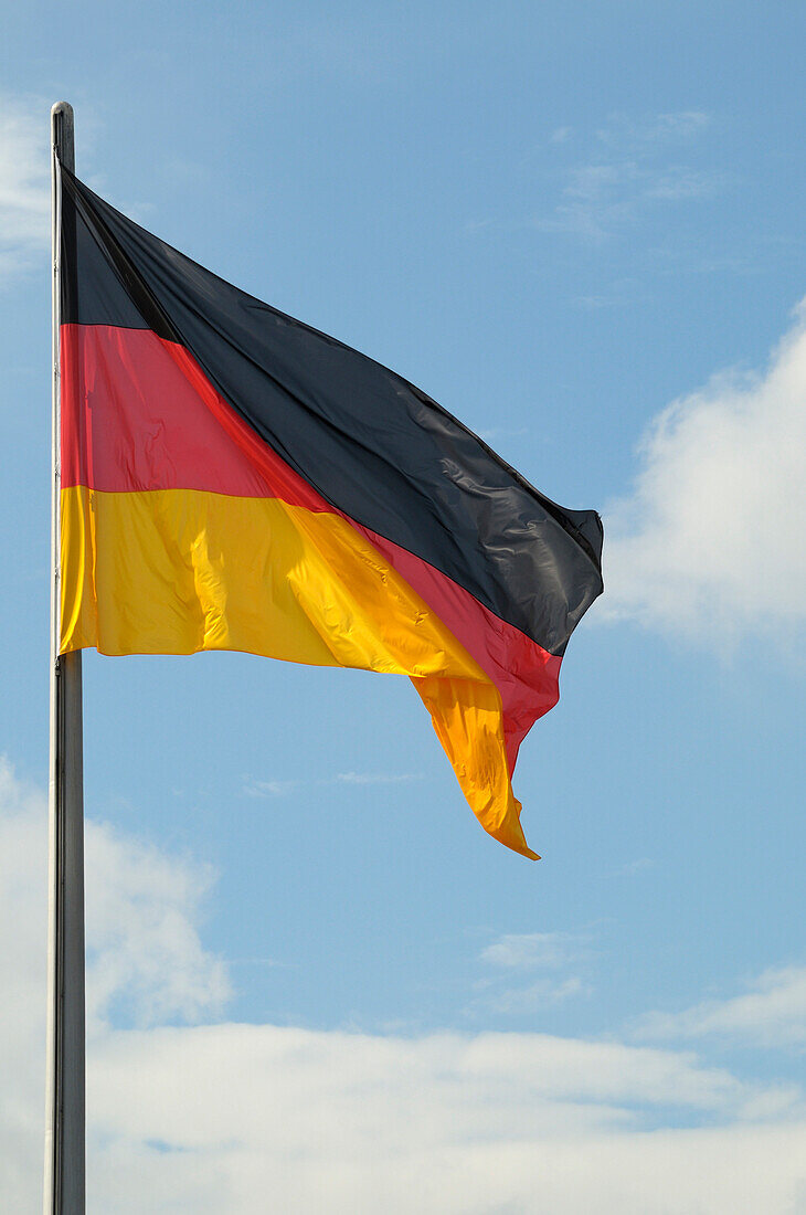 Nahaufnahme der deutschen Flagge vor blauem Himmel