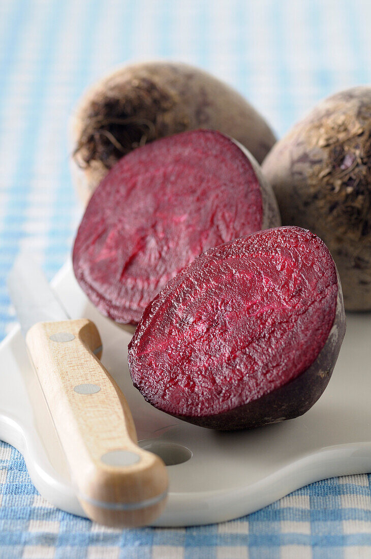 Close-up of Beet Cut in Half on Cutting Board with Knife