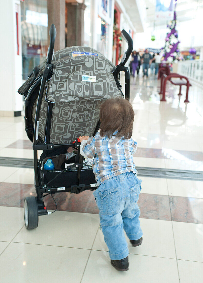 Baby Boy Pushing Stroller in Shopping Mall,Mexico