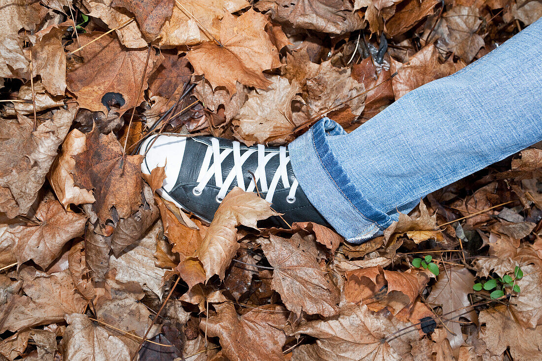 Frau geht im Herbstlaub spazieren