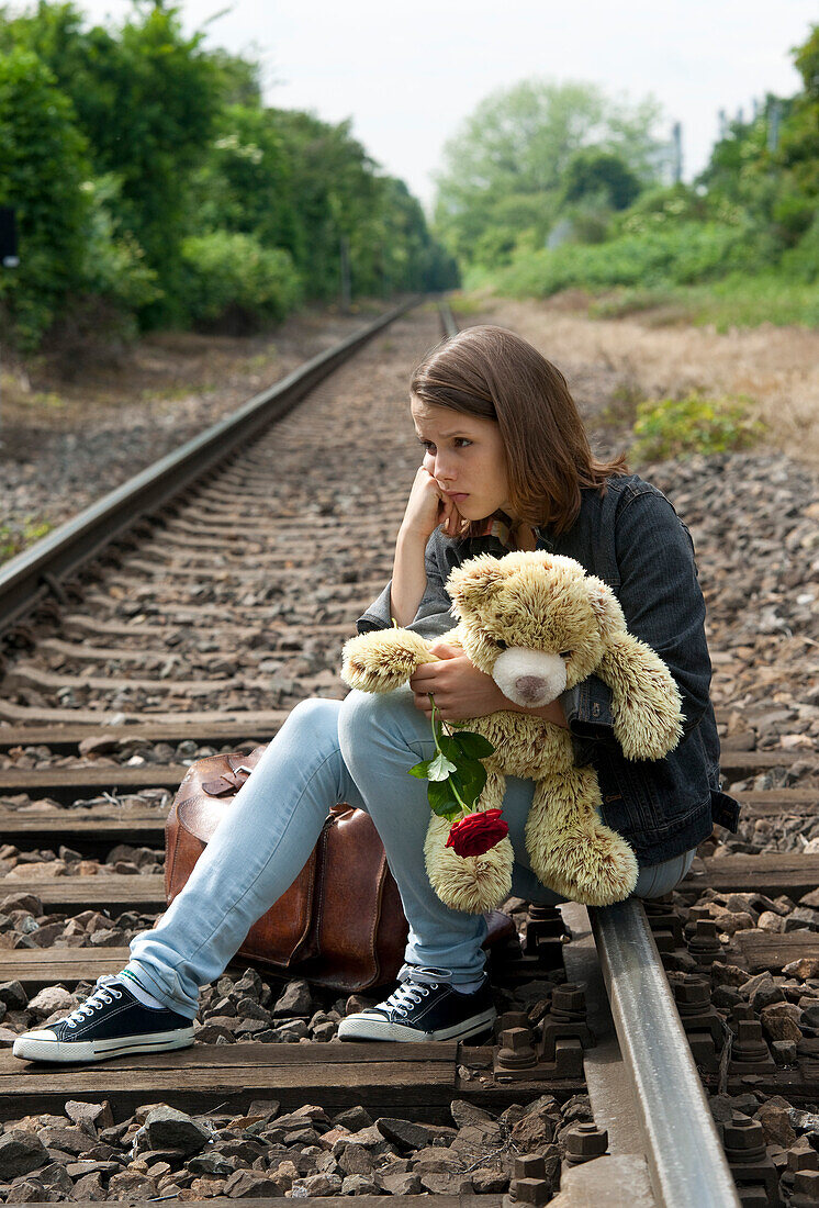 Teenage Girl Sitting on Railway Tracks