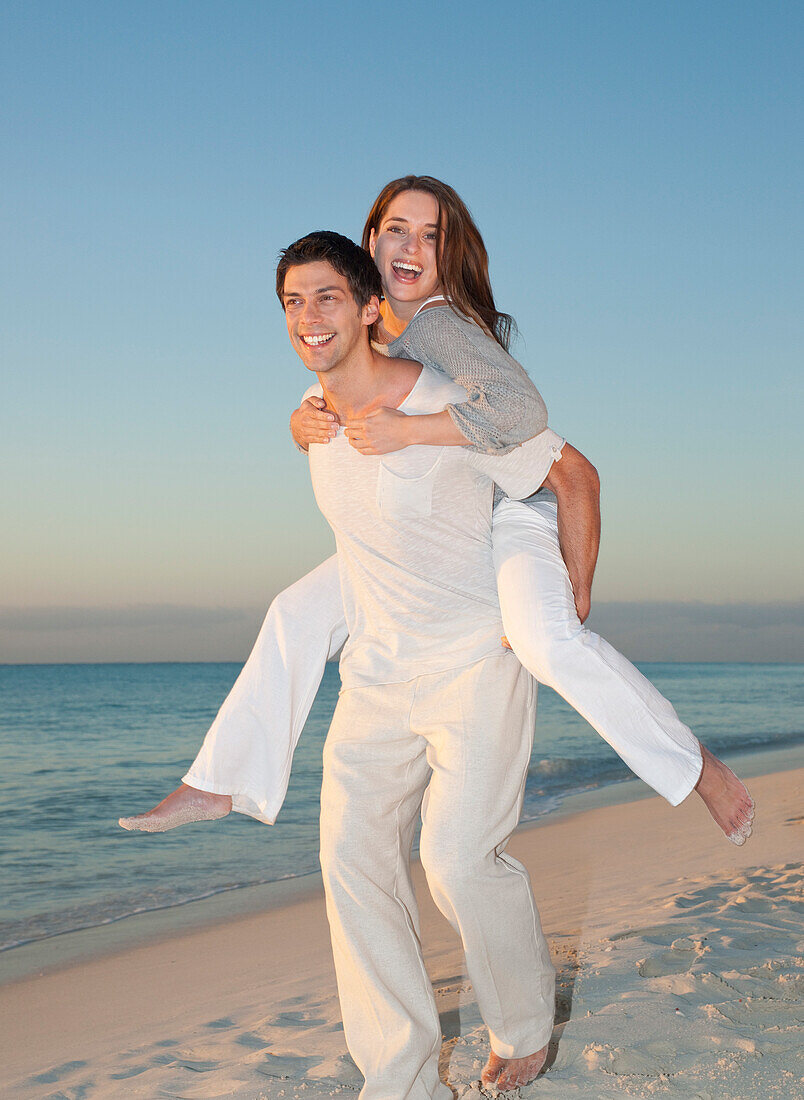 Man Piggybacking Woman on Beach,Reef Playacar Resort and Spa,Playa del Carmen,Mexico