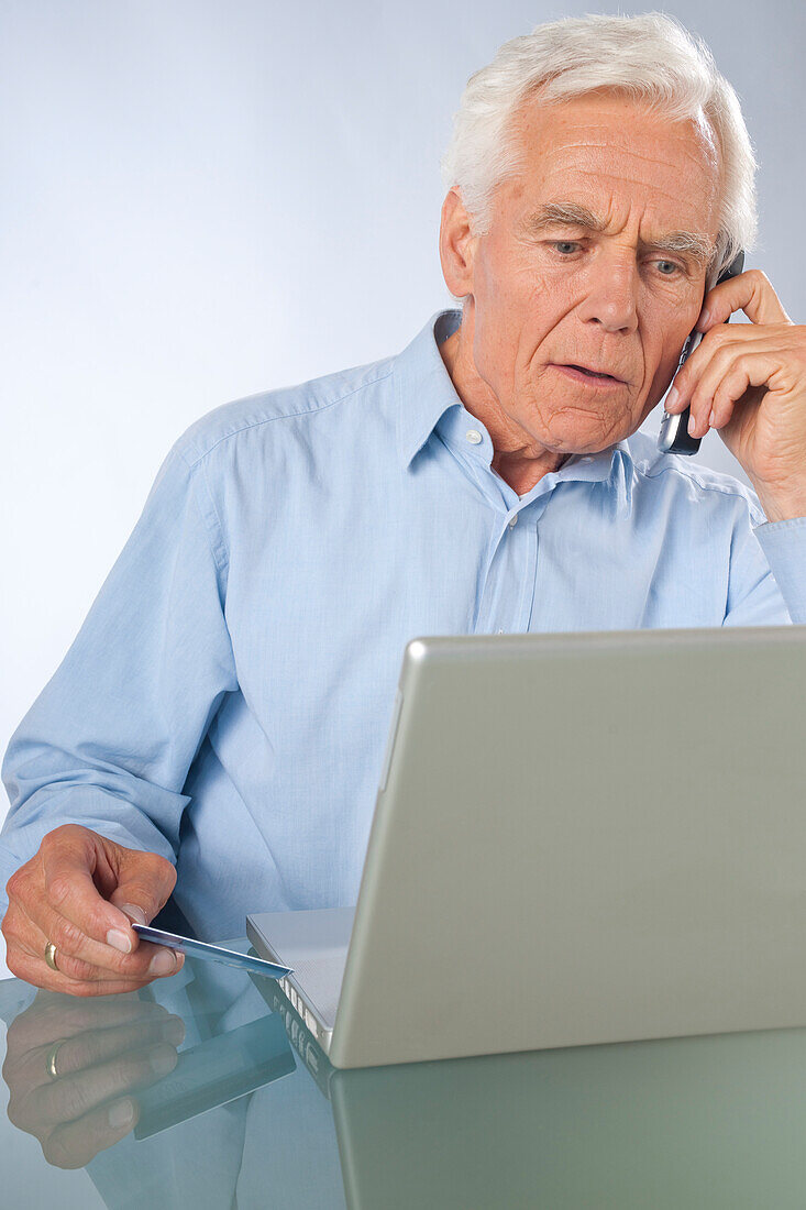 Man using Laptop and Cordless Phone