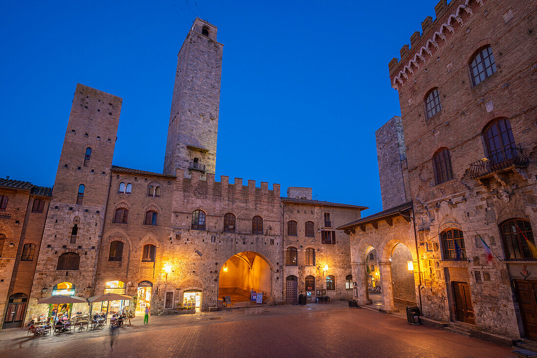 Blick auf Restaurants auf der Piazza del Duomo in der Abenddämmerung, San Gimignano, UNESCO-Weltkulturerbe, Provinz Siena, Toskana, Italien, Europa